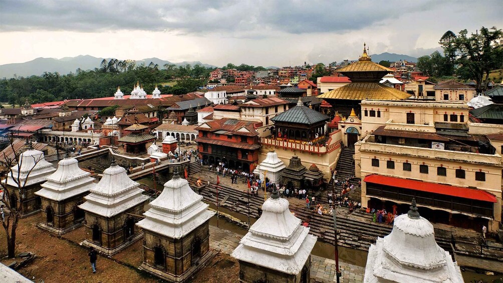 A temple complex with multiple white stupas and a large golden-domed building. 2