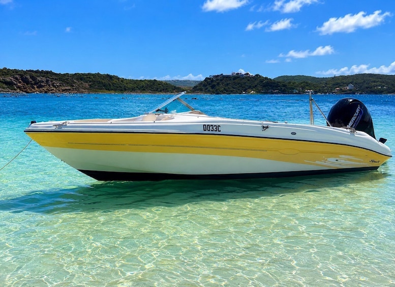 A speedboat with the registration number 0033C anchored in clear blue water. 3