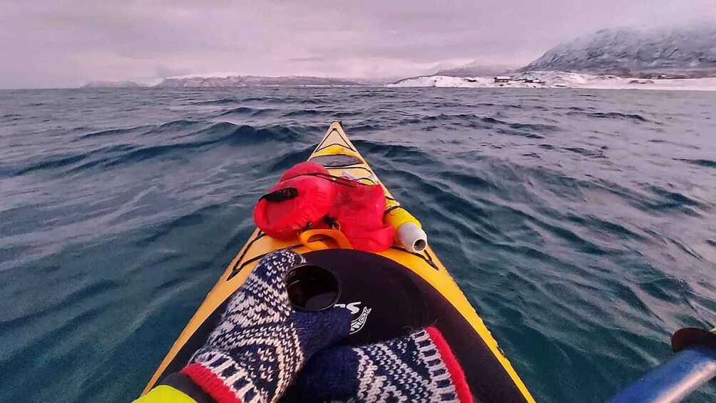 A kayak on a choppy sea with a rocky island in the distance. 1