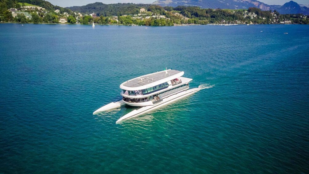 A white boat with a flat deck sailing on clear blue water. 5