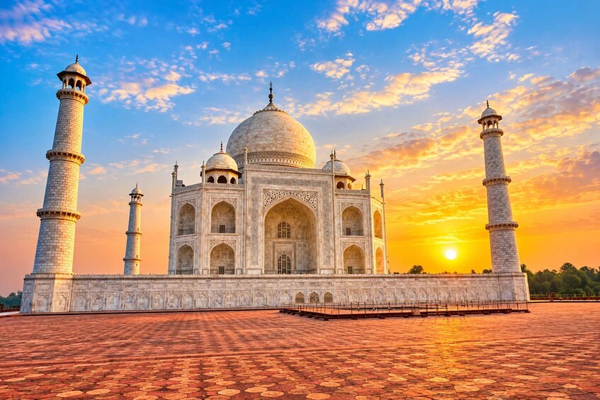 The Taj Mahal with four minarets and a large dome, set against a sunset sky. 1