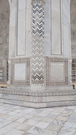 A marble column with intricate patterns and a tiled floor. 5