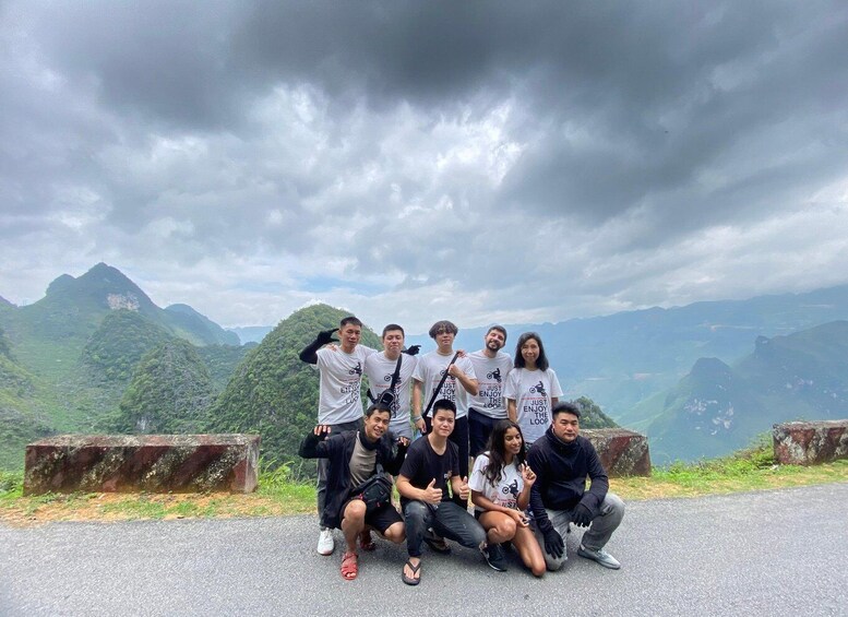 A group of people posing on a road with a mountainous landscape in the background. 2