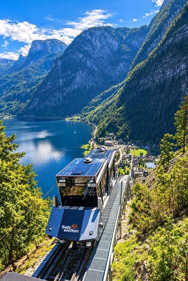 A train on tracks with a mountainous landscape and a lake in the background. 5