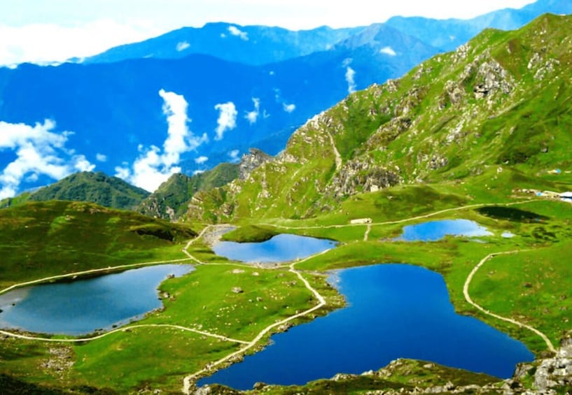 A mountainous landscape with multiple lakes and winding paths. 1