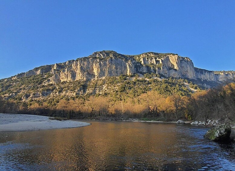 A river reflecting a rocky mountain range with sparse vegetation. 2