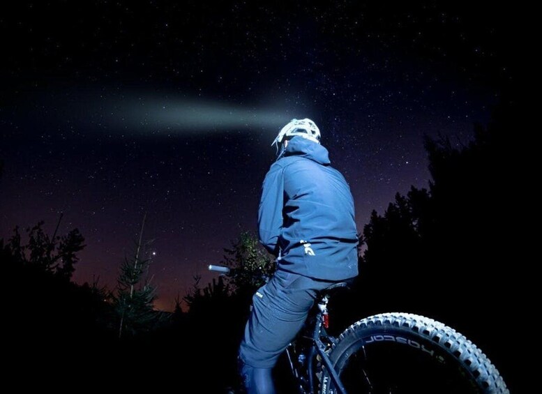 A person riding a mountain bike at night under a starry sky. 3
