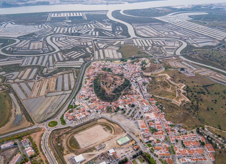 An aerial view of a coastal city with a central historic fort, surrounding residential areas, and a network of roads and waterways. 4