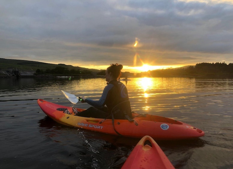 Une personne pratiquant le kayak sur une rivière paisible au coucher du soleil. 2