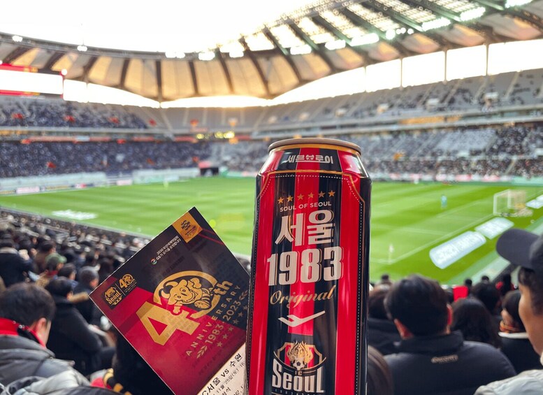 A stadium with a can of beer and a commemorative booklet. 5