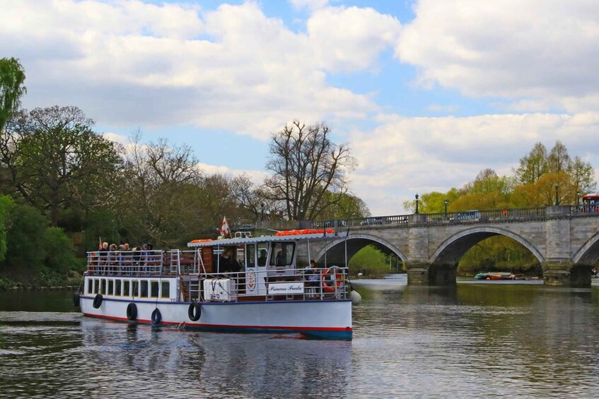 A white boat with red and blue stripes named "Princess Freda" on a river. 3