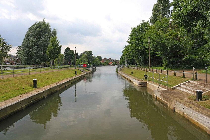 A canal with a lock system, surrounded by grassy banks and trees. 2