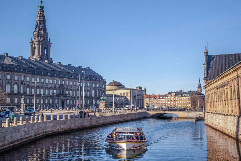 A canal with a boat, historic buildings, and a bridge. 2