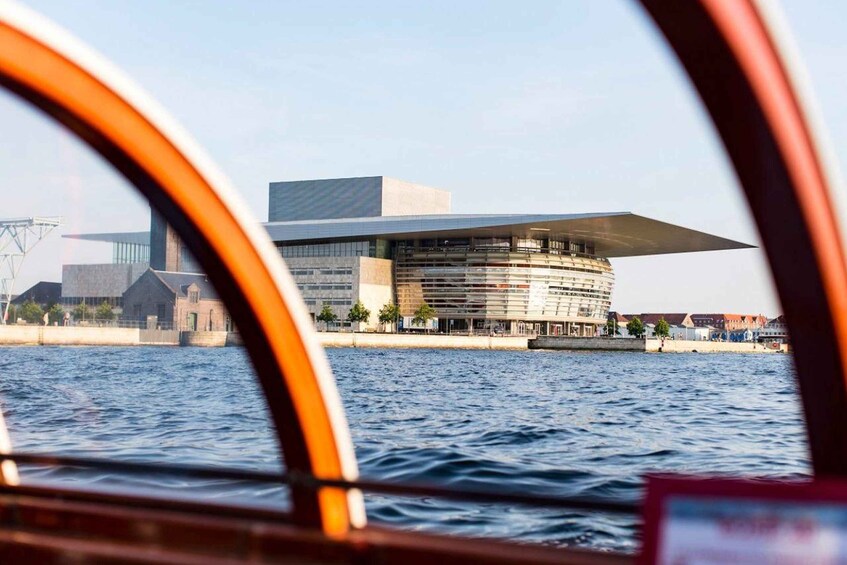 A modern building with a unique architectural design, situated by a body of water. 3