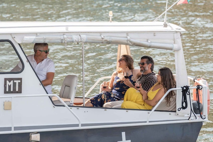 A boat with four people on board, a white exterior, and the letters 'MT' on the side. 5