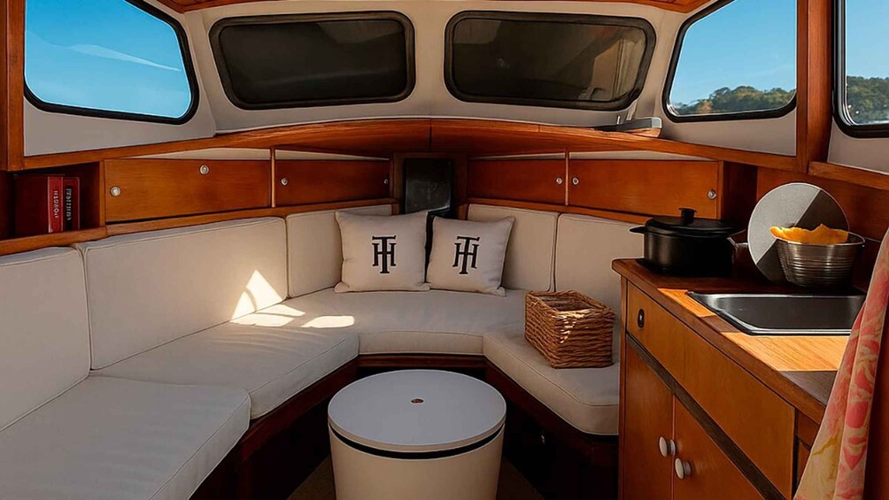 A cozy interior with a cushioned seating area, a small round table, and a compact kitchen setup. 4