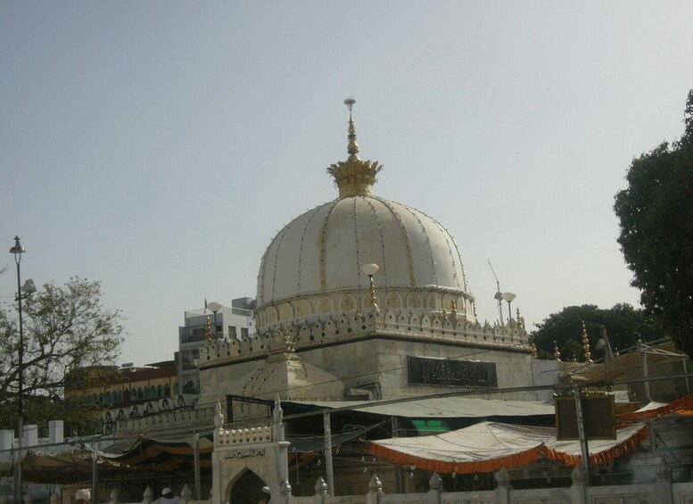 A large white dome with gold accents, surrounded by traditional architecture. 2
