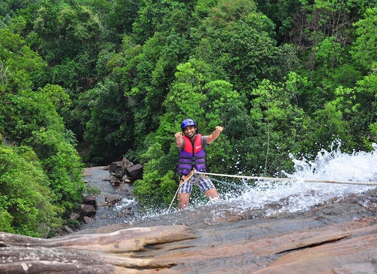 Una persona haciendo rafting en un río rodeado de un bosque verde y frondoso. 1