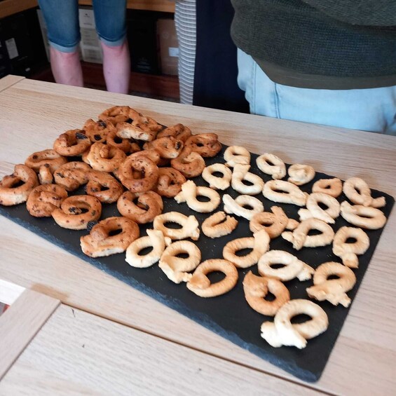 A tray of assorted doughnuts on a wooden table. 1