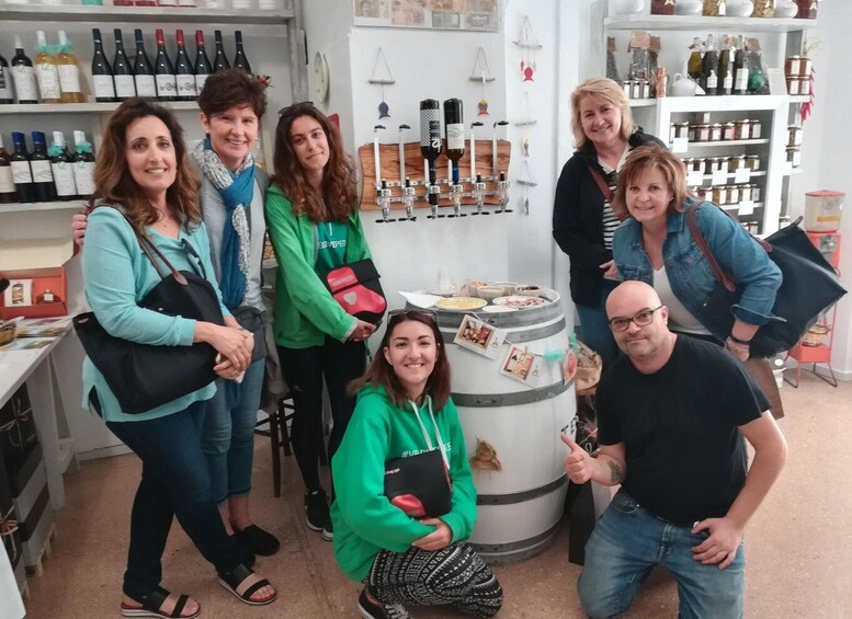 A group of people in a store with shelves of wine bottles and various items. 5