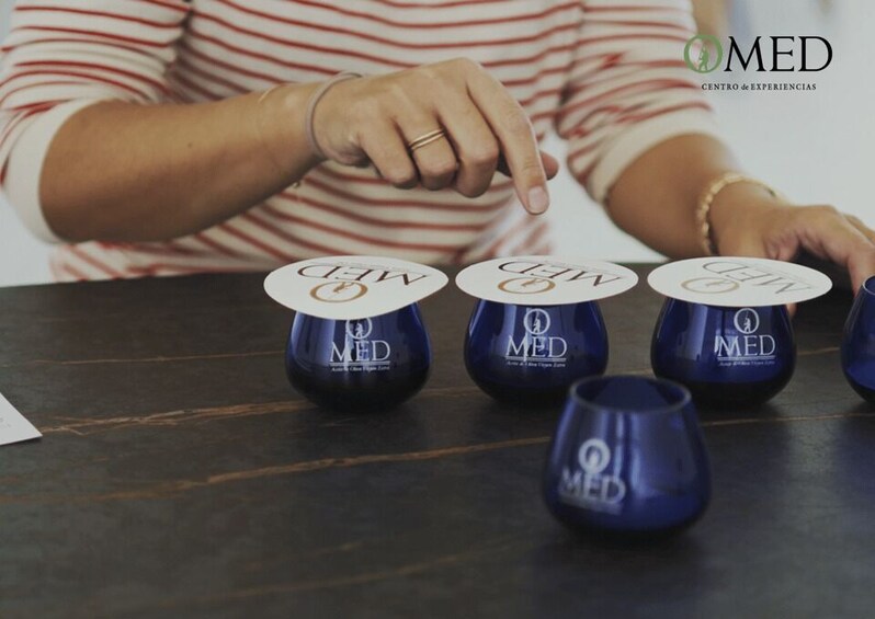 A person arranging blue cups with 'MED' logos on a table. 2