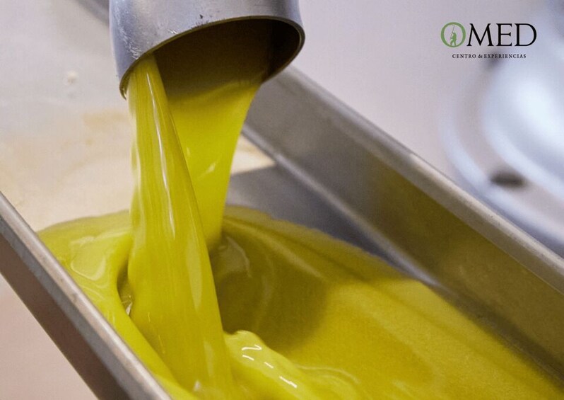 A metal container with a yellow liquid being poured out. 3