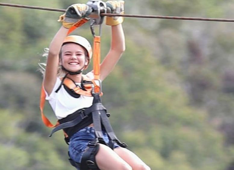 A person zip-lining with safety gear, surrounded by greenery. 5