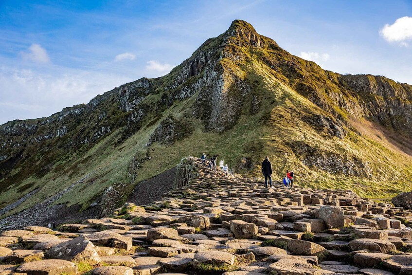 A stone pathway leading up a mountain with hikers. 5