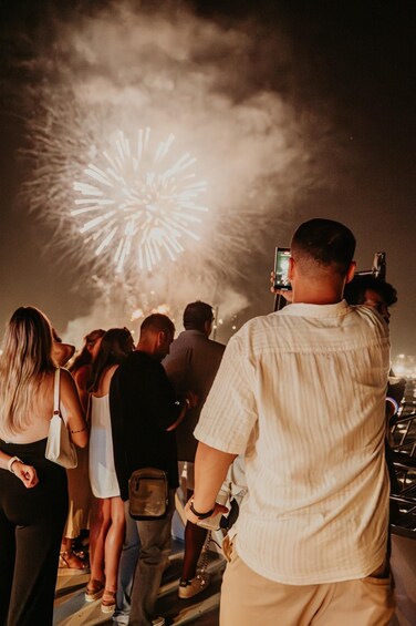 A group of people watching fireworks. 1