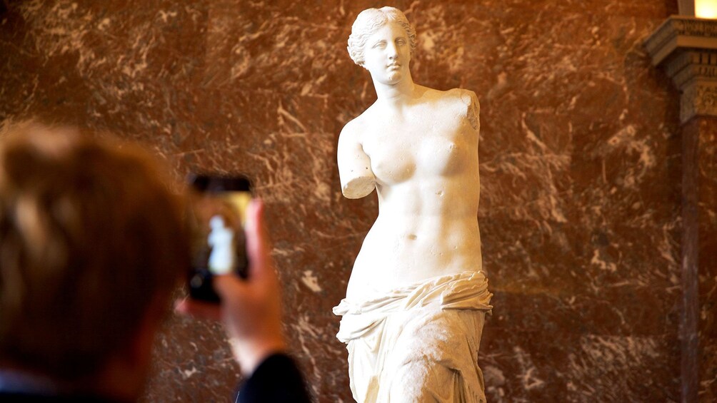 En marmorstatue af en afklædt figur i et museum. 1