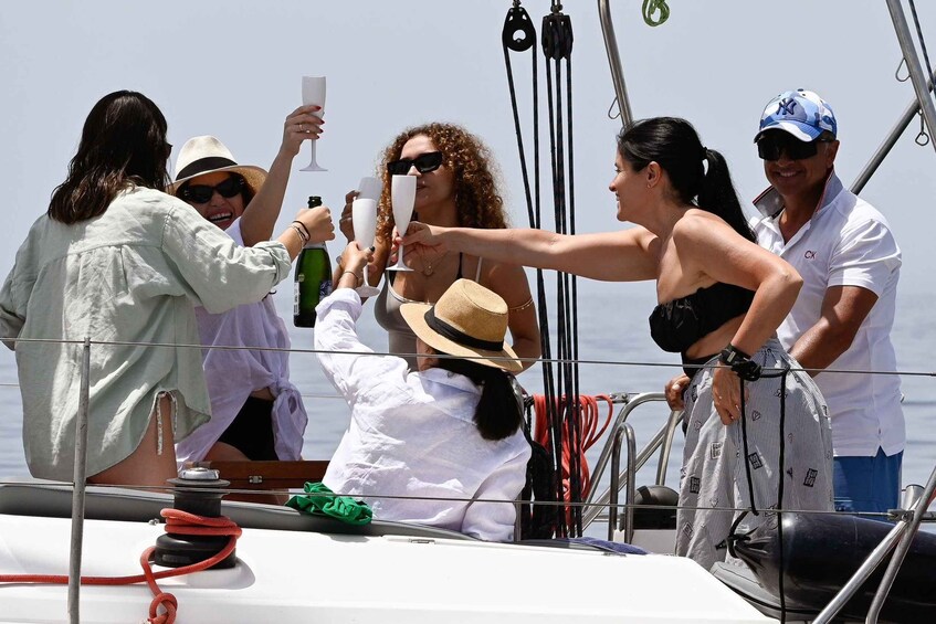 A group of people on a sailboat, holding champagne glasses. 1