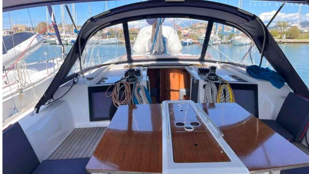 A boat's deck with a table, seating, and ropes. 4
