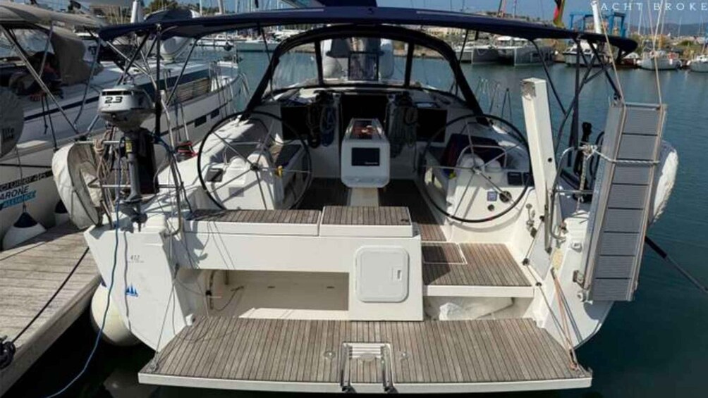 A sailboat docked at a marina with a wooden deck and various navigational equipment. 5