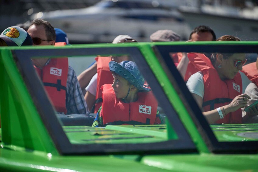 A green car with people wearing life jackets. 4