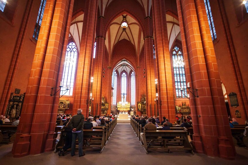 A church interior with high vaulted ceilings and red brick walls. 2