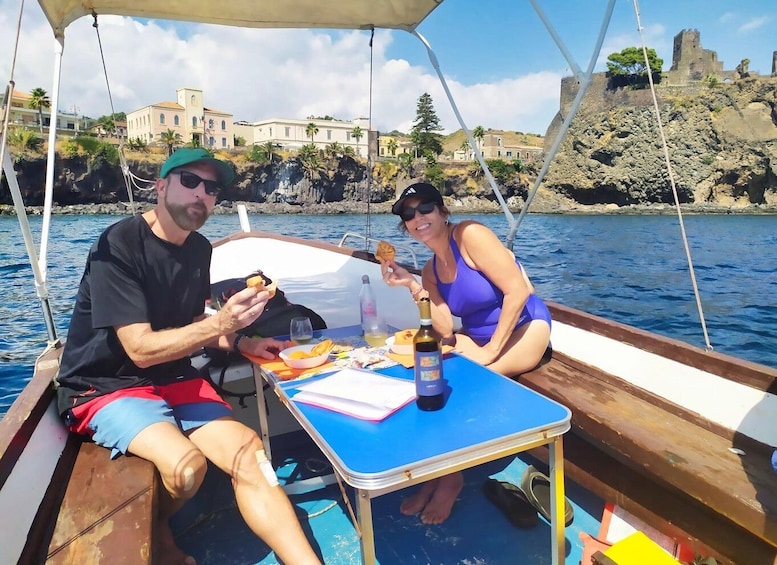 Due persone su una barca con un tavolo, cibo e una bottiglia. 2