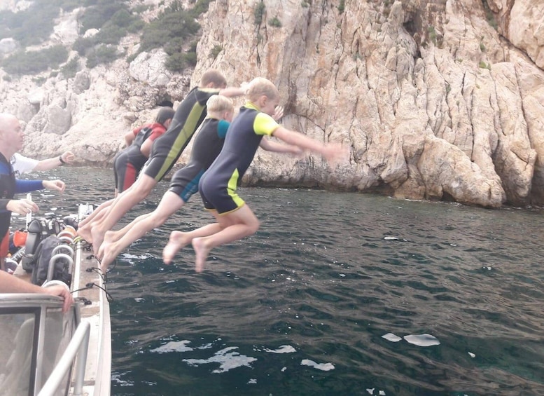 People jumping off a boat into the water. 3