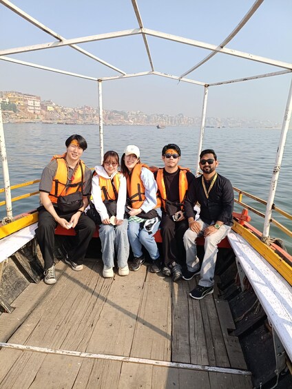 A group of people on a boat with a cityscape in the background. 5