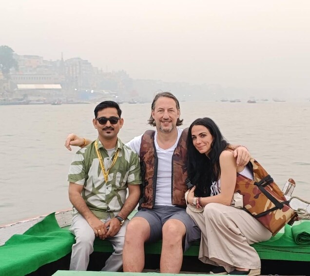 Three people on a boat with a cityscape in the background. 4