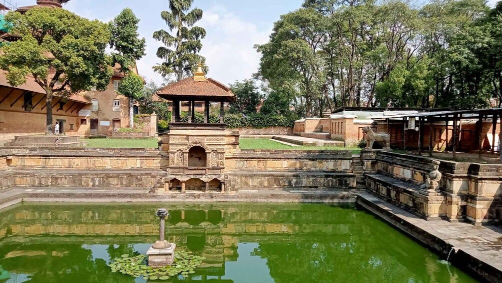 A historical site with a central water feature, stone steps, and traditional architecture. 5