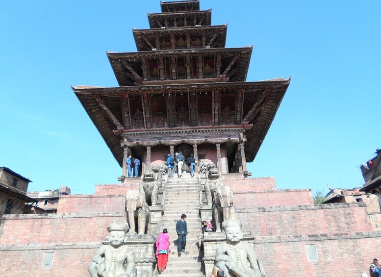 A multi-tiered pagoda-style structure with intricate carvings and statues at the base. 5