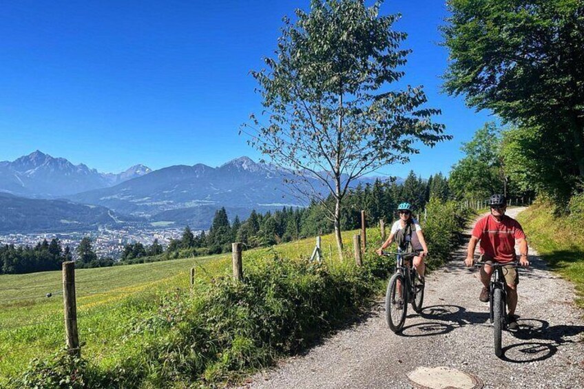 Dos ciclistas en un camino de grava con una vista de montaña al fondo. 1