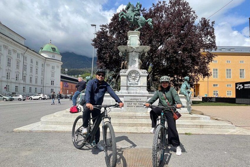 Due persone in bicicletta davanti a una statua. 5