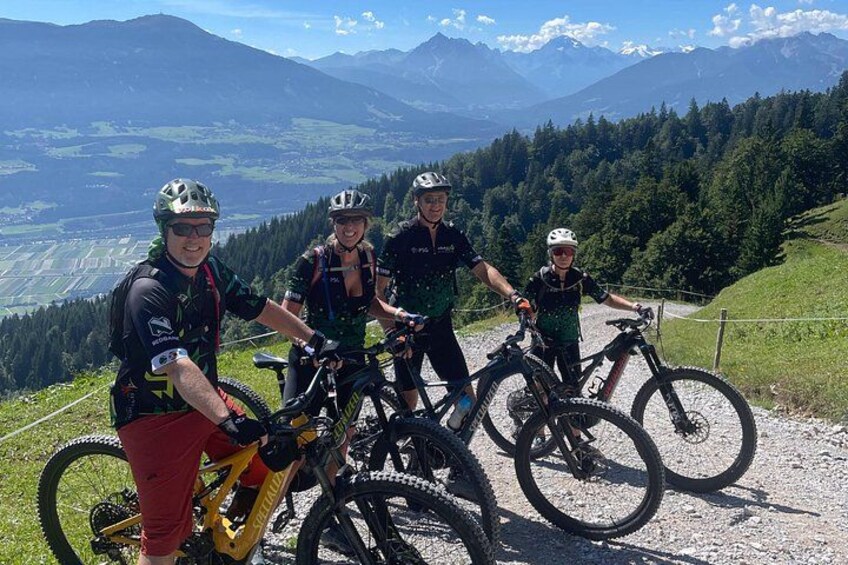 Un gruppo di ciclisti su un sentiero di montagna con una vista panoramica su montagne e foreste. 2