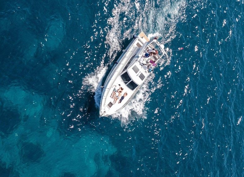 Un bote blanco con pasajeros navegando en aguas azules cristalinas. 2