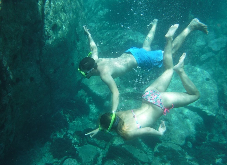 Two people snorkeling underwater. 4