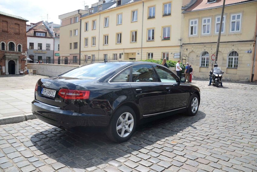 Ein schwarzes Auto auf einem Kopfsteinpflasterweg in einer europäischen Stadt. 2