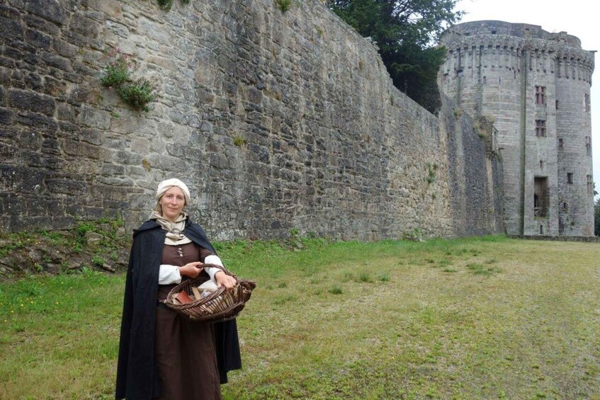A person standing in front of a stone wall and a castle. 3