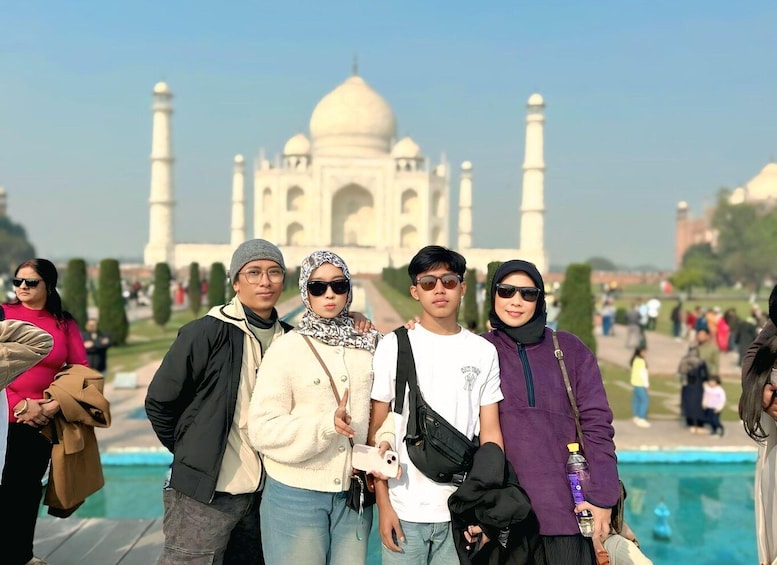 Un grupo de personas de pie frente al Taj Mahal. 2
