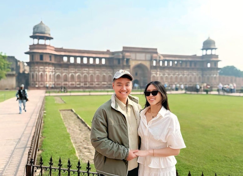 Una pareja está de pie frente a un gran edificio histórico con torres en forma de cúpula. 3